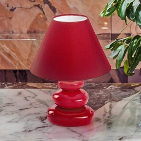 Rote Tischlampe mit schmalem Schirm auf einer marmorierten Oberfläche.