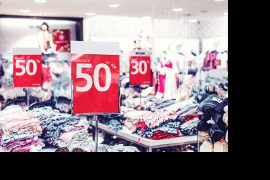 Verkäufsschilder im Geschäft: 50% und 30% Rabatt auf Kleidung.