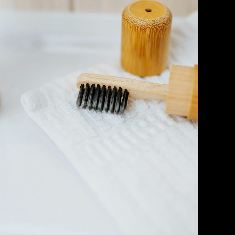 Holzhaarpinsel und -roller auf einem weißen Handtuch liegen.