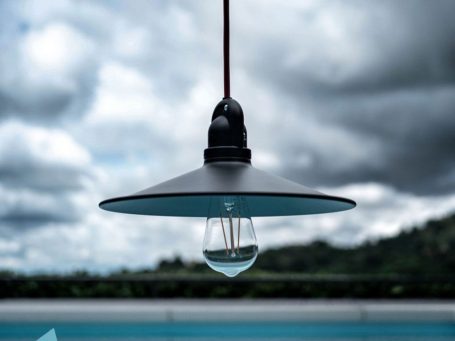 Hängende Lampe über einem blauen Pool mit einem Wassertropfen darunter.
