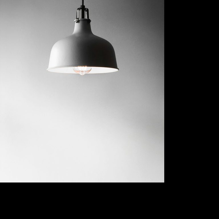 Hängende Lampe mit weißem Schirm in minimalistischem Design.