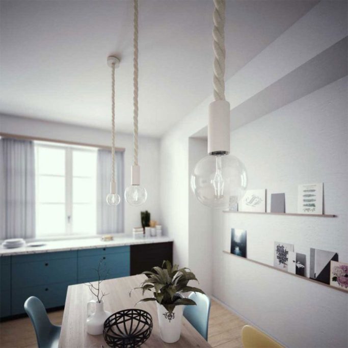 Moderne Küche mit Esstisch, hängenden Lampen und bunten Stühlen.