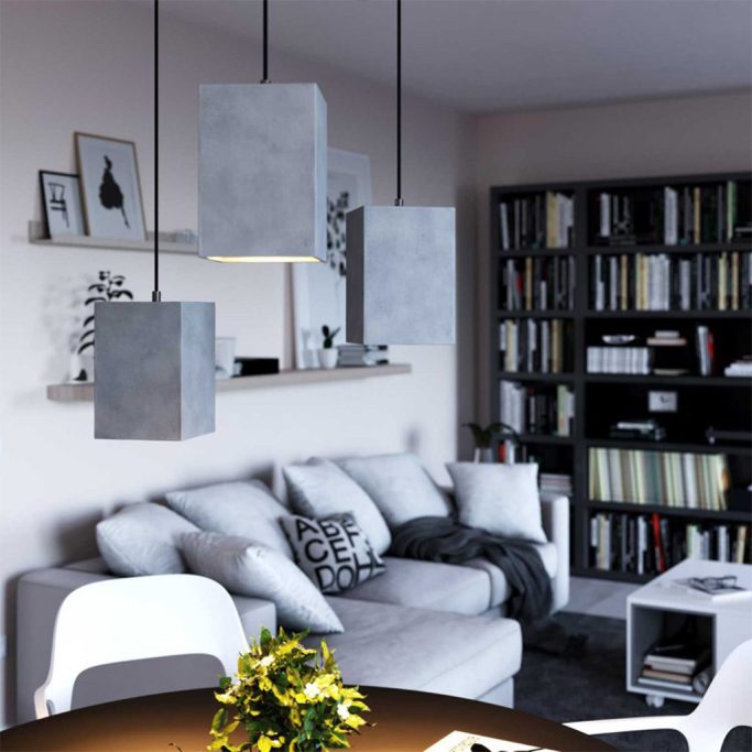 Helles Wohnzimmer mit grauen Lampen, Sofa und Bücherregal.